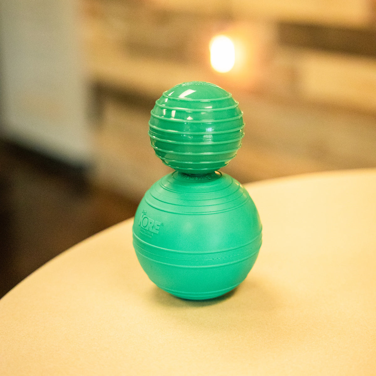 Two green KOREflex Squeak natural rubber dog balls stacked on a table
